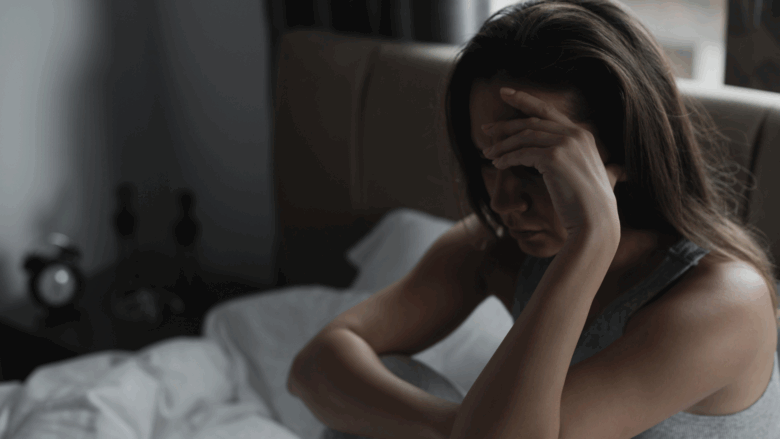 Woman is sad and depressed sitting in her bed